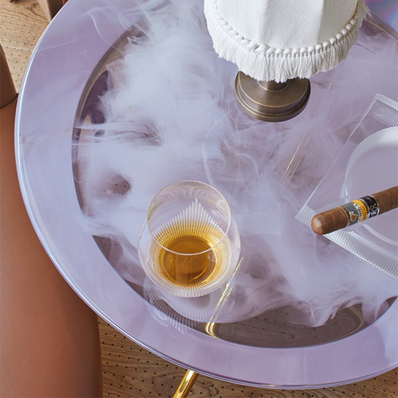 The Connaught Cigar Merchants - detail shot of table with whisky in glass, cigar on the side and table lamp.