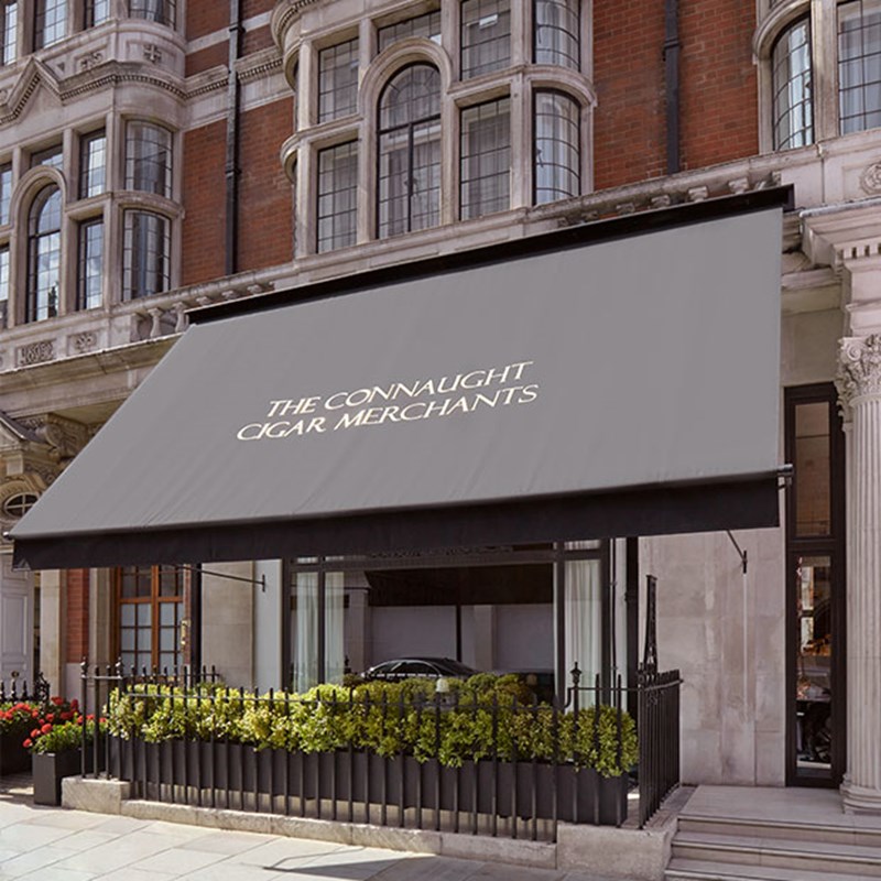 The Connaught Cigar Merchants Street View with awnings and plants.