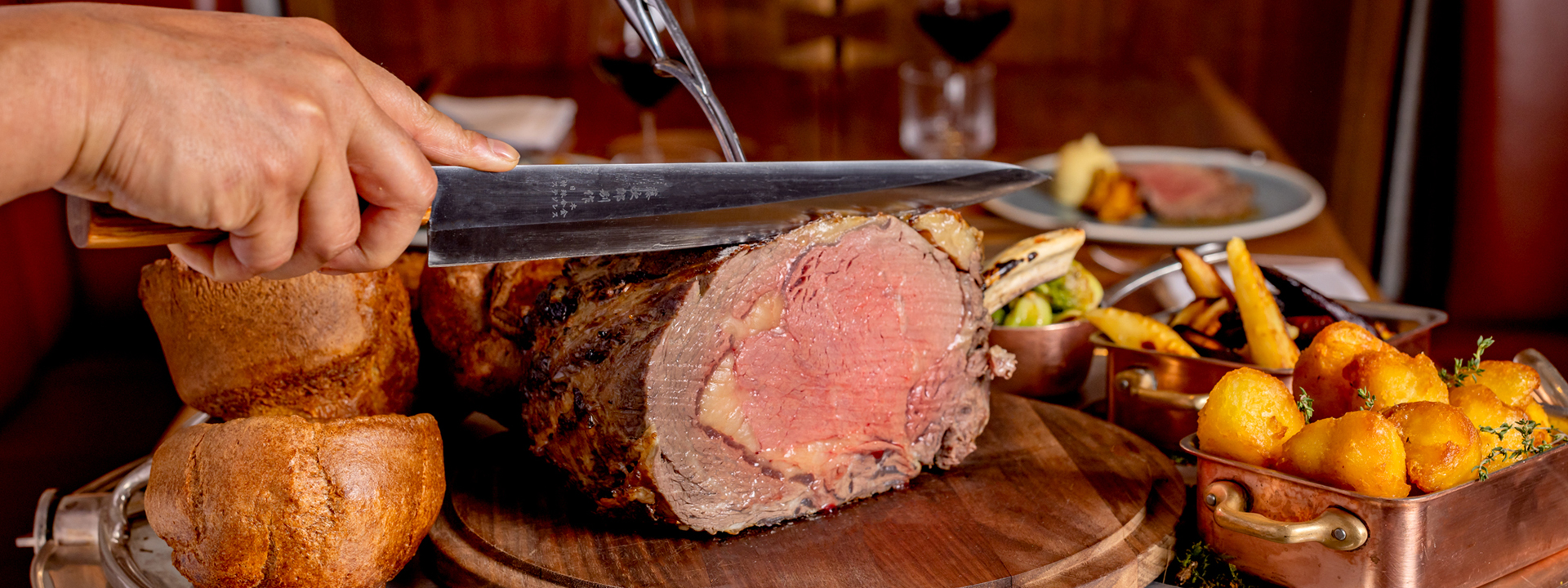 Sunday Roast at The Connaught Grill - Meat being cut with an assortment of side dishes.